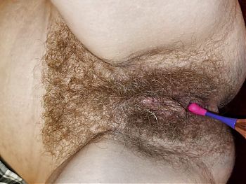 Stimulating a juicy hairy cunt with a pin point vibrator